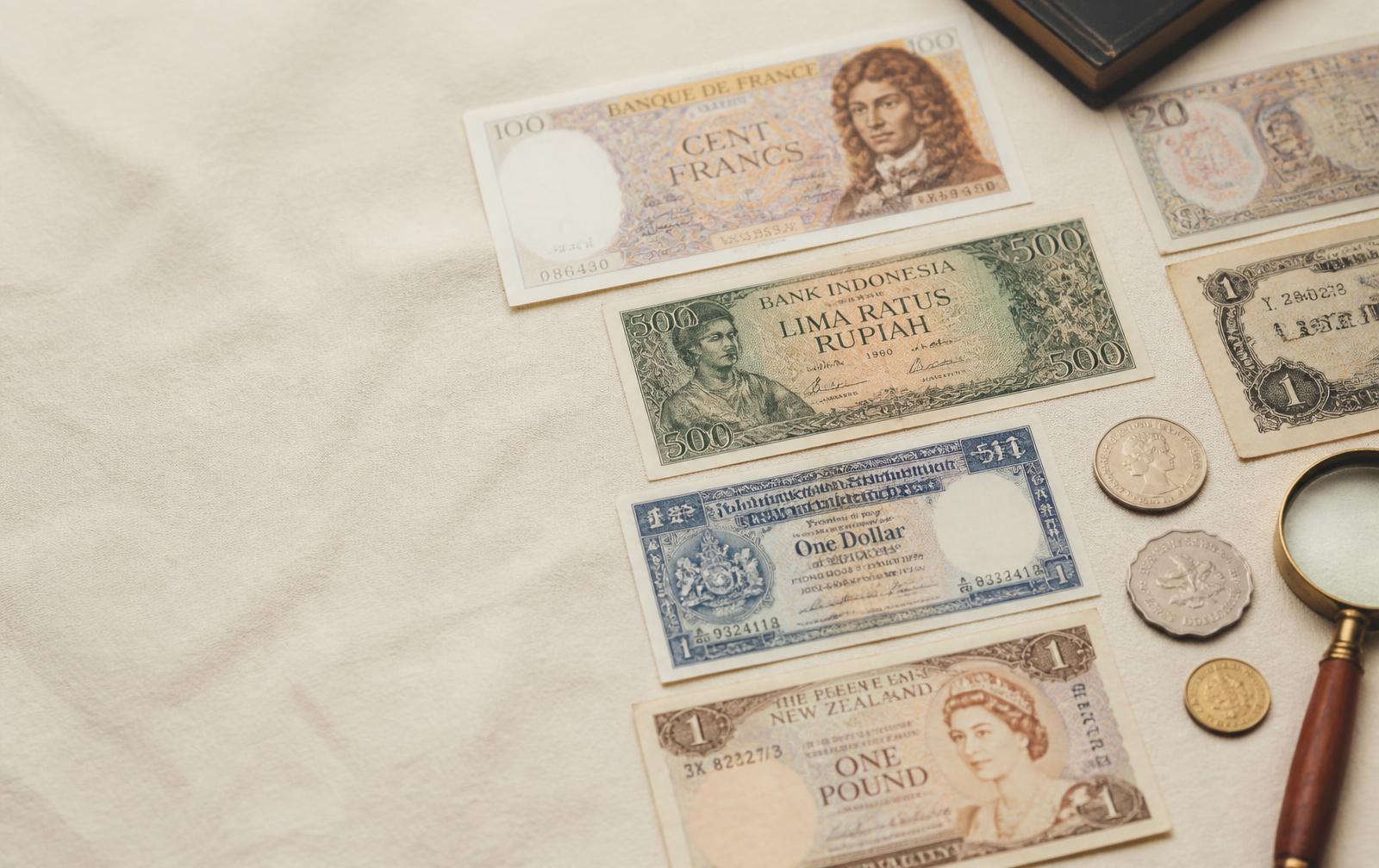 Collectible banknotes and coins laid out on linen